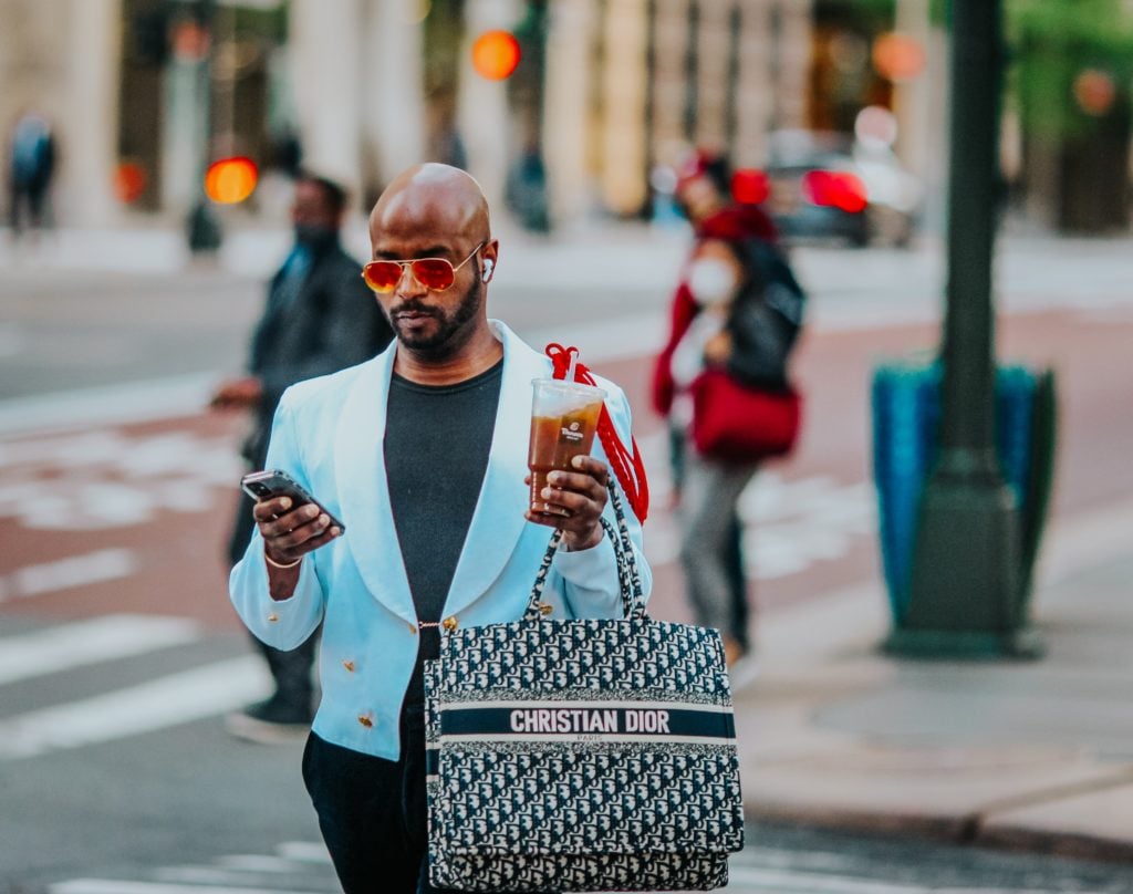 Image showing a man with a Christian Dior bag and expressing his luxury lifestyle